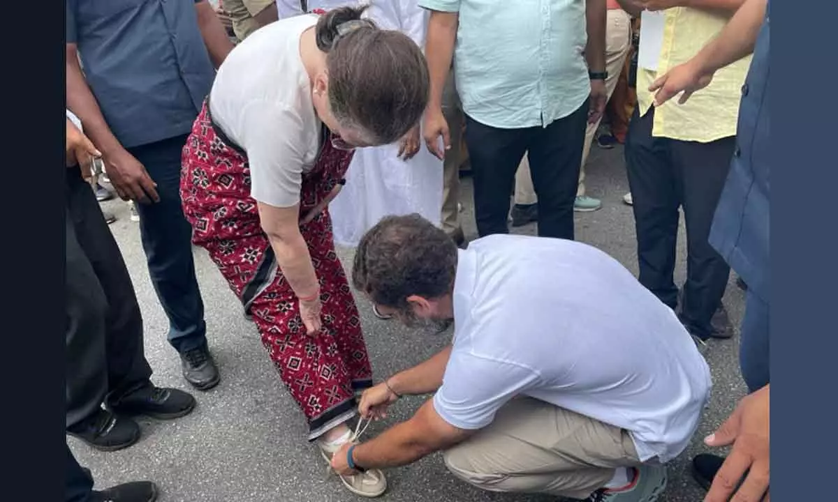 Congress leader Rahul Gandhi ties the shoelaces of his mother and party interim president Sonia Gandhi during the partys Bharat Jodo Yatra, in Mandya district on Thursday