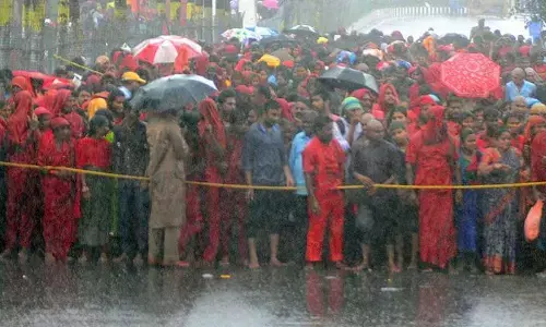 Bhavani devotees braving the rain to have Goddess Kanaka Durga darshan atop Indrakeeladri in Vijayawada on Thursday