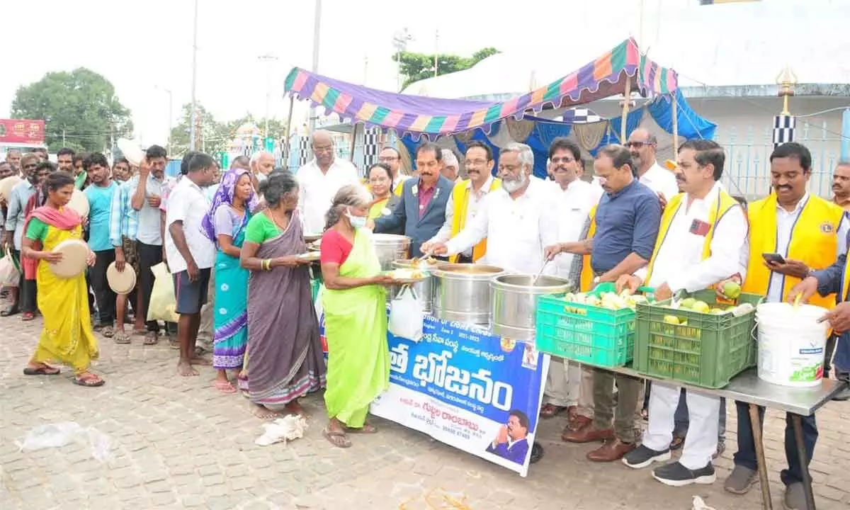 Dr Gubbala Rambabu and other Lions dignitaries distributing food on 365th day of Annadanam at Pushkarghat in Rajahmundry on Friday