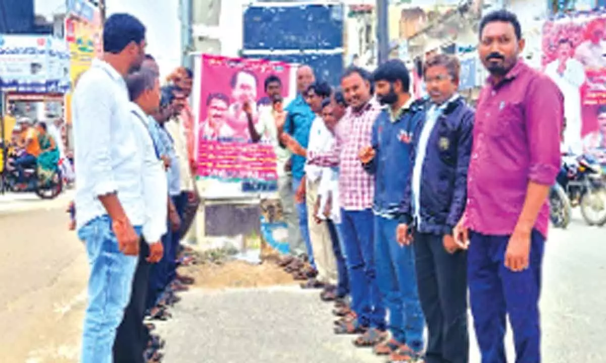 Members of Gopala Mitra Sangham expressing their thanks to CM KCR and Minister Singireddy Niranjan Reddy by pouring milk on their potraits at Rajive Circle in Wanaparthy on Friday
