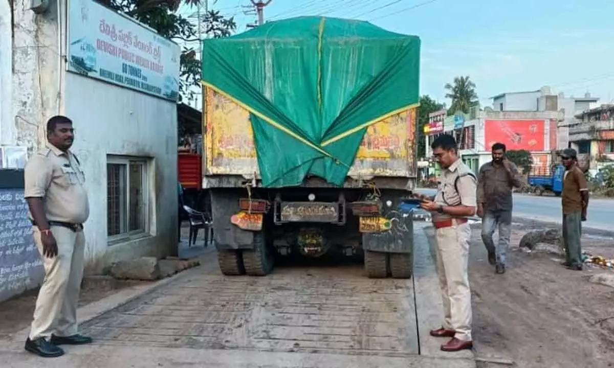 RTO officials verifying records of a goods vehicle for overloading in Visakhapatnam on Friday