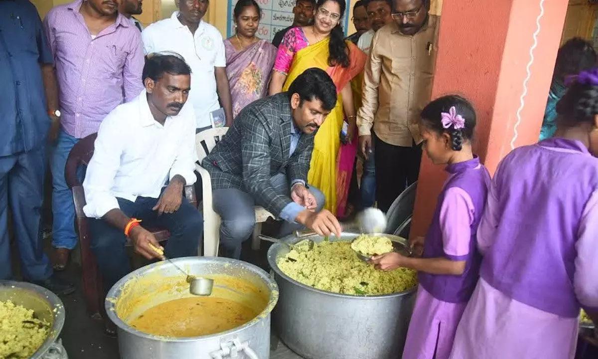 State Food Commission chairman Ch Vijay Pratap Reddy serving midday meal to students of ZPH School, Vepagunta in Visakhapatnam on Tuesday