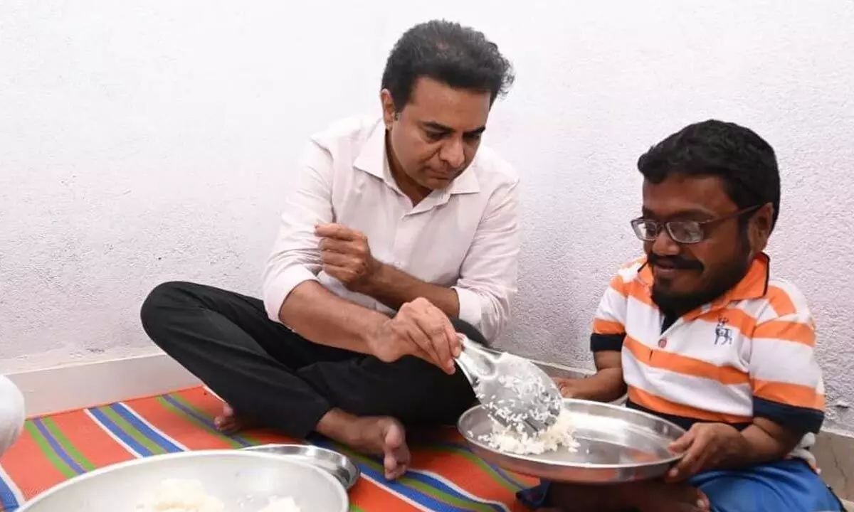 TRS working president K T Rama Rao serving food to fluorosis victim Amshala Swamy at his house in Shivannagudem in the Munugodu Assembly constituency on Thursday
