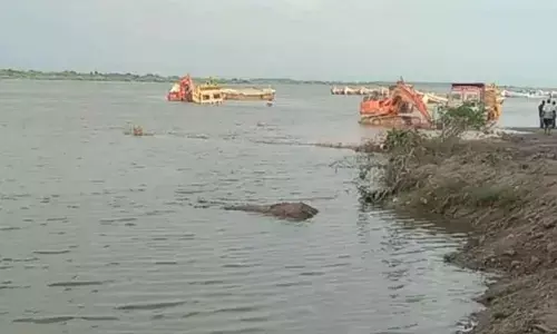 The two lorries that got stuck in floodwater in Krishna river in Achampet mandal on Friday