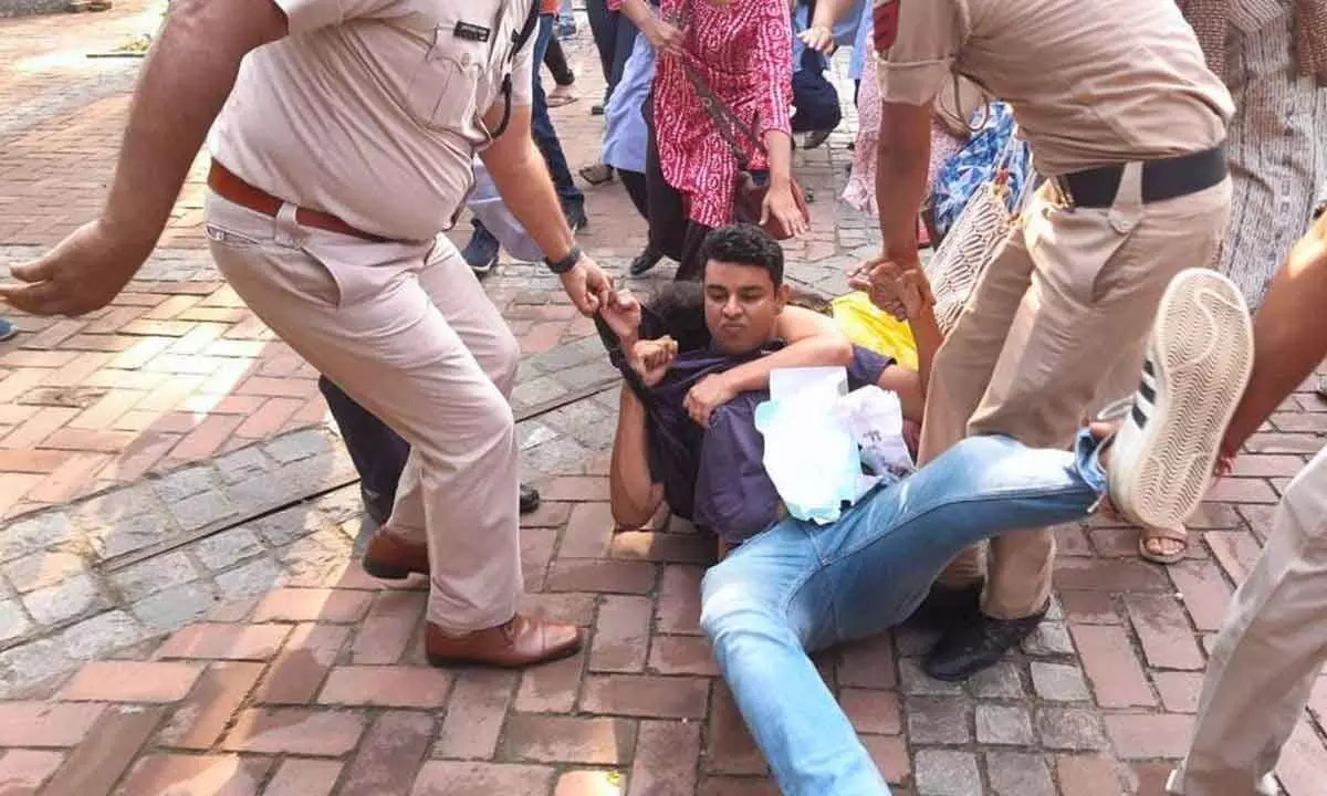 Police personnel remove AISA acivists who had gathered at the Arts Faculty campus of the Delhi University for a public meeting to welcome GN Saibaba, in New Delhi on Saturday
