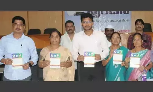 Joint collector M Naveen (centre) releasing pamphlet on National Food Security Act in Srikakulam on Monday