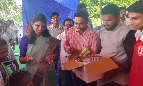 West Godavari District Collector P Prasanthi distributing essential commodities to slum dwellers at Tanuku on Tuesday
