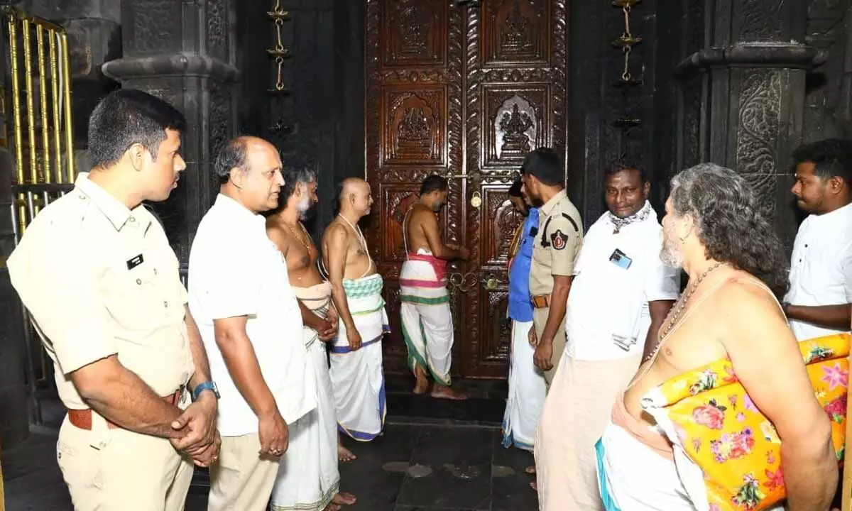 Archakas and temple officials closing down the doors of Sri Varaha Lakshmi Narasimha Swamy temple on the solar eclipse day in Visakhapatnam on Tuesday