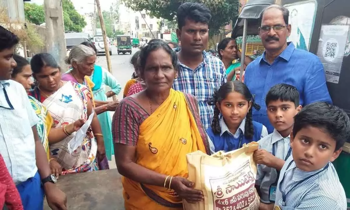 Students of Nirmala High School distributing essential commodities to the people in Vijayawada on Friday