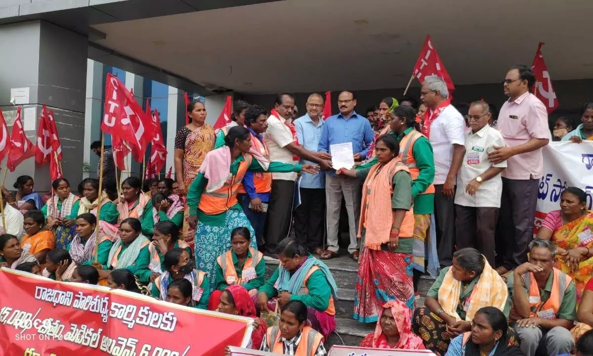 Sanitary workers, led by CITU leaders, submitting a memorandum to Deputy Collector Sai Babu at CRDA in Tulluru on Monday