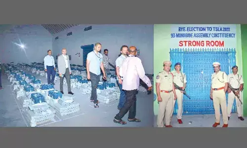 Officials inspecting the strong room where EVM are stored in Munugodu constituency on Friday; Police personnel keeping guard of strong room