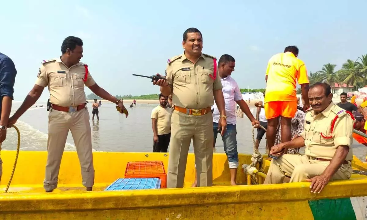 Police moving on boats to monitor movements of pilgrims taking bath in the sea at Suryalanka Beach in Bapatla district on Sunday