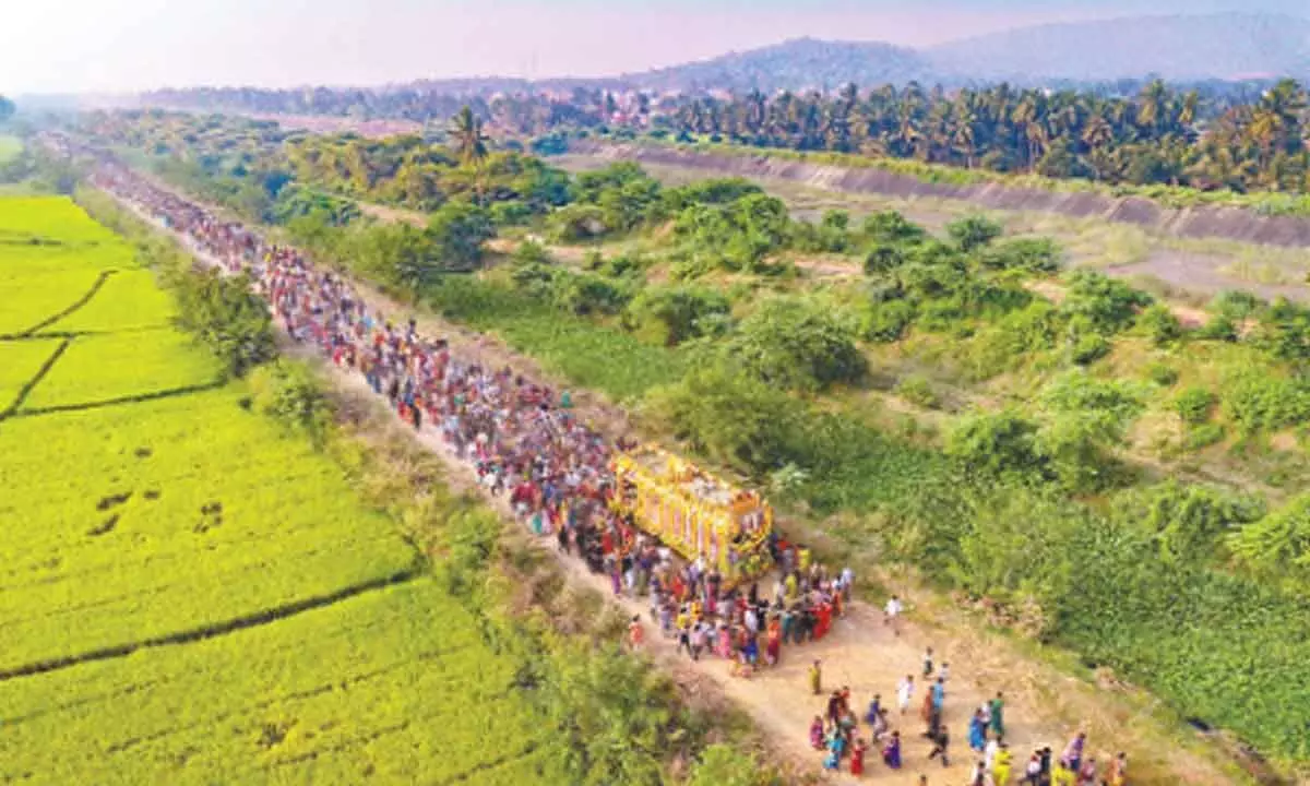 Devotees walking along the chariot of Sri Veera Venkata Satyanarayana Swamy for Giri Pradakshina in Ratna Giri hills, Annavaram, on Tuesday