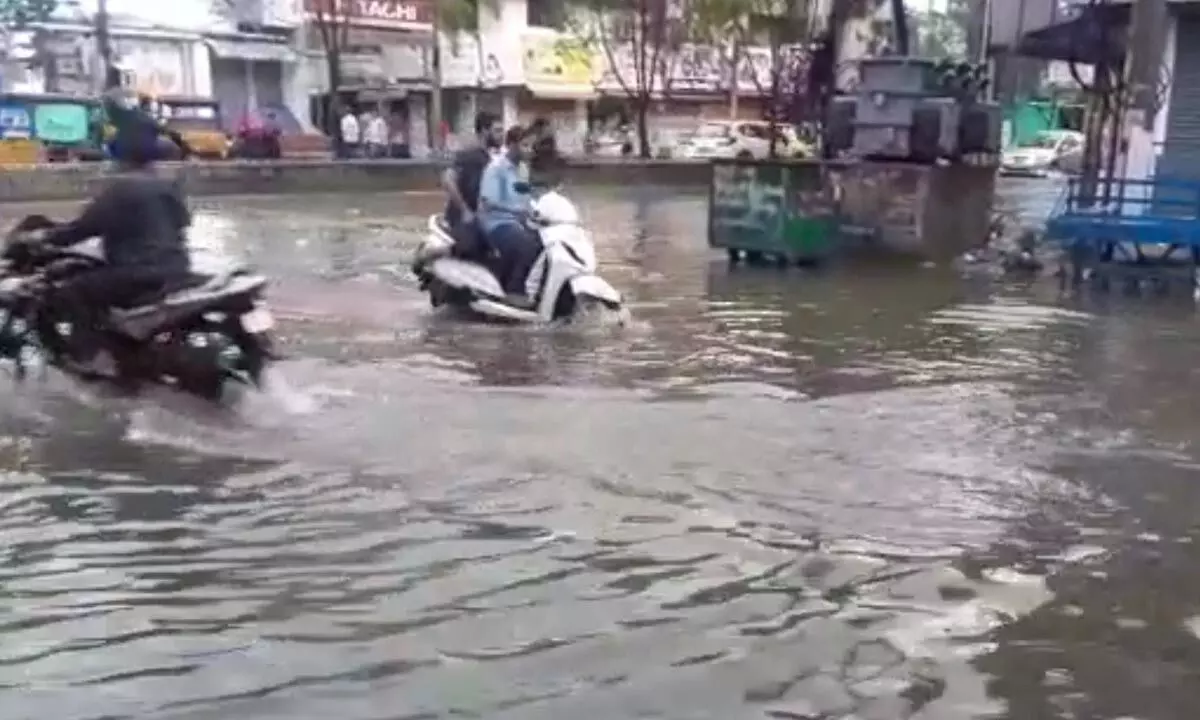 A biker wades through rainwater at Rayaji Street in Nellore on Sunday