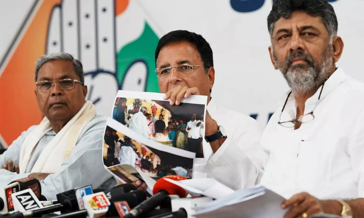 Congress leader Randeep Surjewala with party leaders  D K Shivakumar and Siddaramaiah addresses a press conference  at party office in Bengaluru on Thursday