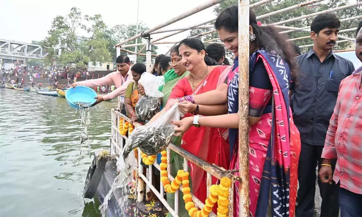 District Collector K Madhavi Latha and others releasing fish fingerlings in Godavari river at Pushkar Ghat in Rajamahendravaram on Monday