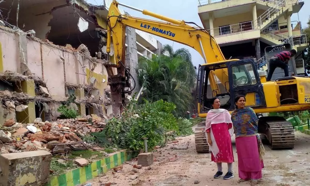 Mayor Dr R Sirisha inspecting the demolition works of the municipal office old building near the main mark in Tirupati on Tuesday. Divisional Engineer Devika is also seen.
