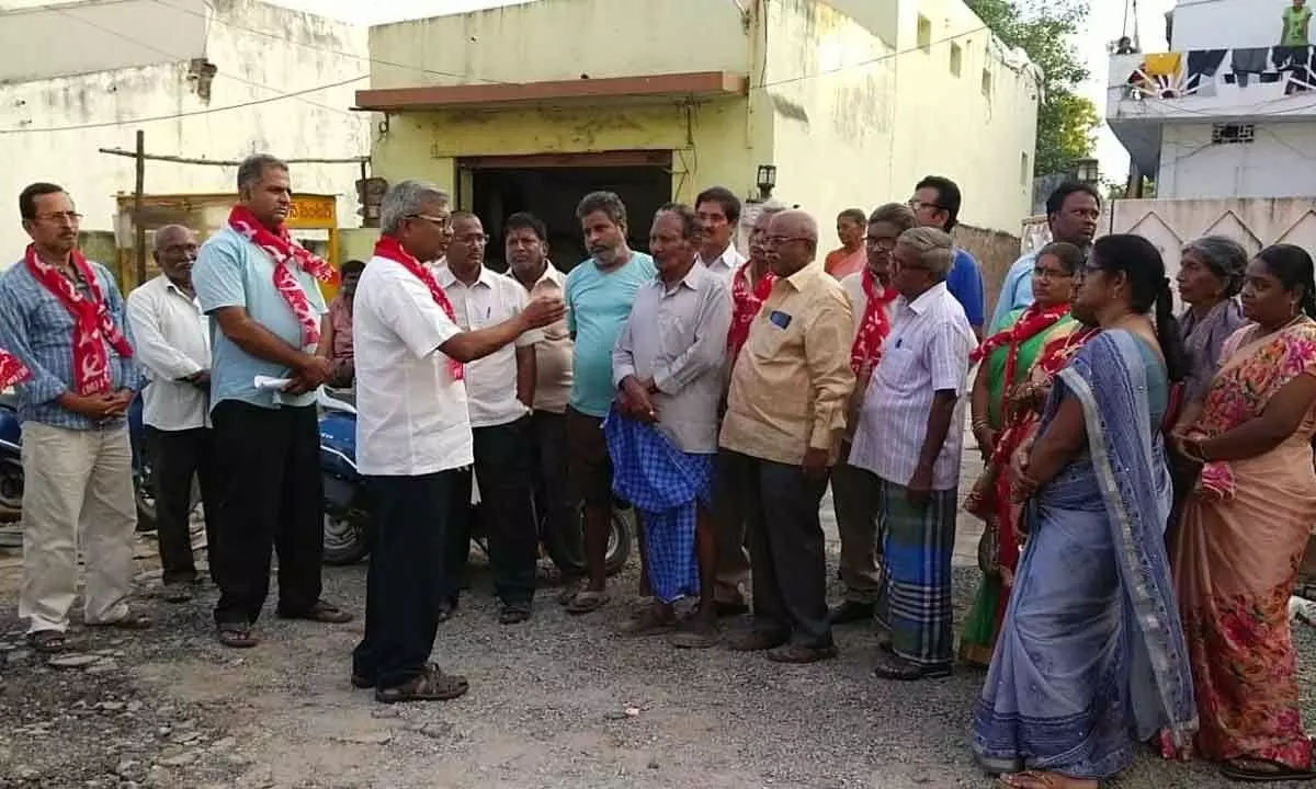 CPM State executive member Ch Babu Rao interacting with house owners, whose houses demolished during road widening, at Chandrayya Nagar in Guntur on Thursday