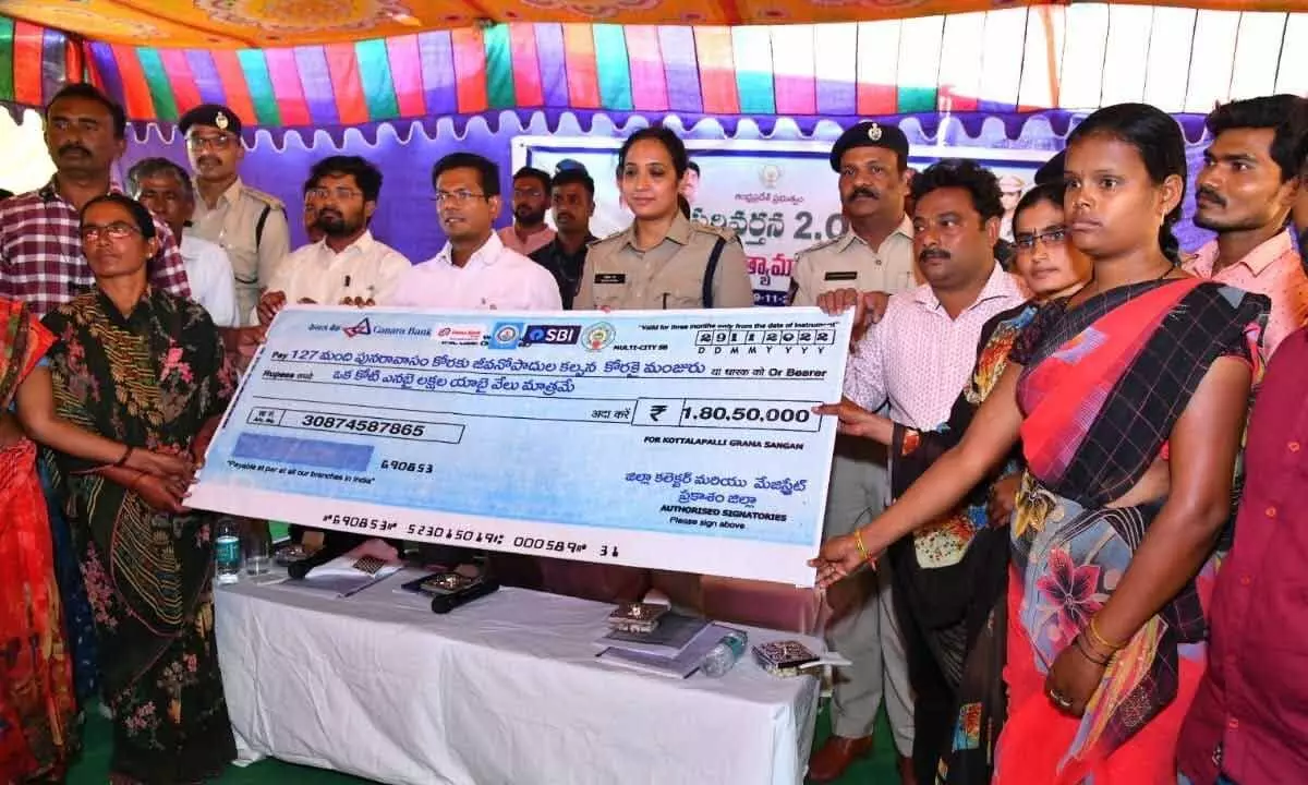 Prakasam District Collector AS Dinesh Kumar, SP Malika Garg and other officials handing over a cheque to people, who stopped illegal liquor brewing, at a programme in Markapuram on Tuesday