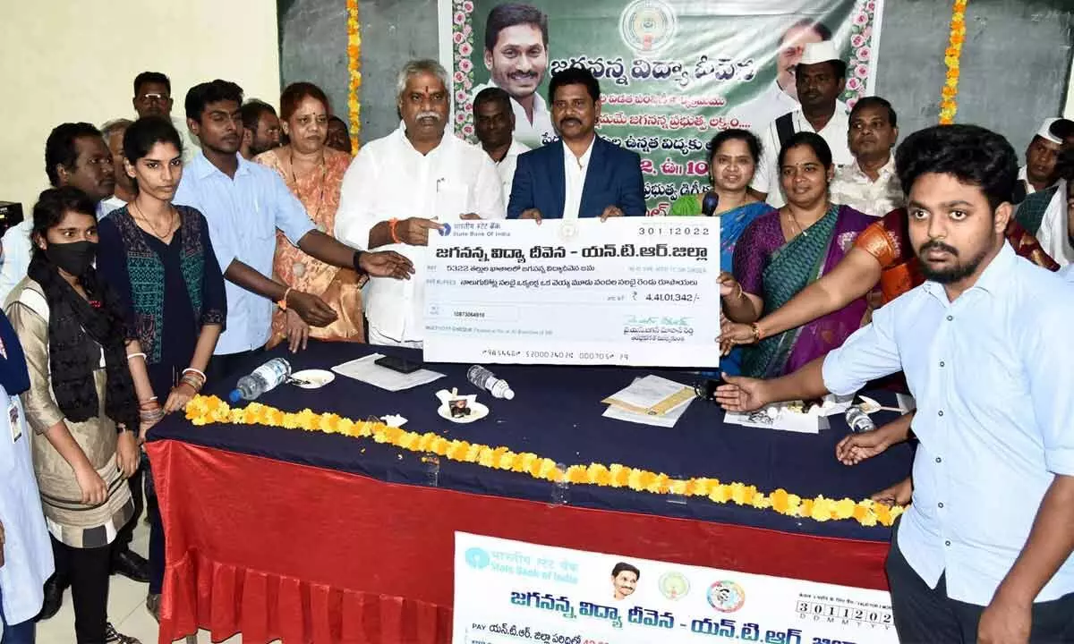 Vijayawada Central MLA Malladi Vishnu and District Collector S Dilli Rao handing over specimen cheque to students at a programme in Vijayawada on Wednesday
