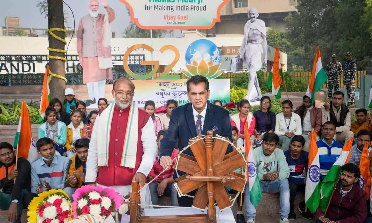 G20 Sherpa Amitabh Kant with former union minister Vijay Goel spins a charkha during the unveiling of a display of the G20 logo at Mandi House Chowk in New Delhi on Thursday