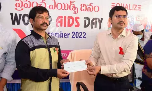 District Collector A Mallikarjuna handing over a cheque for Rs 1.1 lakh to DLO  Dr Poornender Babu in Visakhapatnam on Thursday