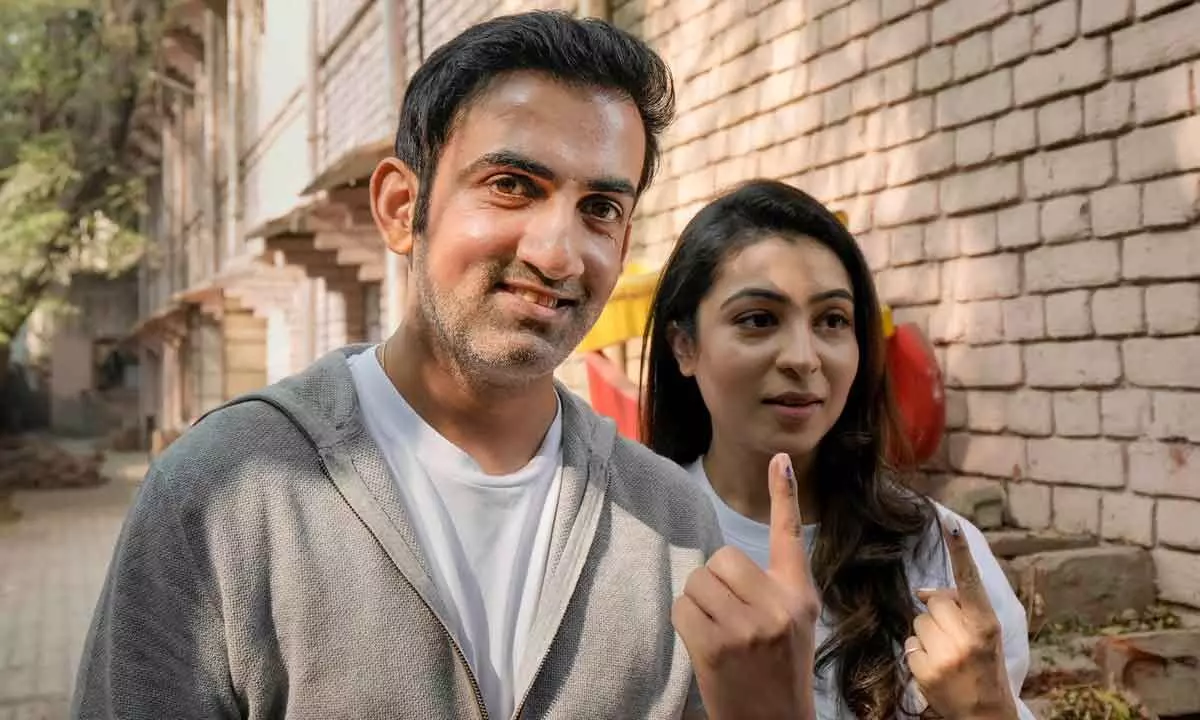 BJP MP Gautam Gambhir and his wife Natasha Jain show their fingers marked with indelible ink after casting their votes for the MCD elections.