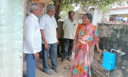 CPM State executive member Ch Babu Rao and other leaders observing a water meter fixed in a house in Madhura Nagar in Vijayawada on Friday