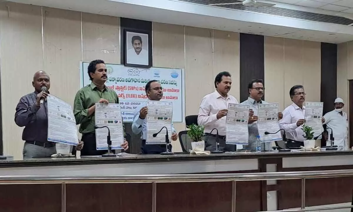District Collector V Prasanna Venkatesh, DRO P Kishore and others releasing awareness posters on plastic ban items of SUPs and flexi banners at a programme in Eluru on Friday