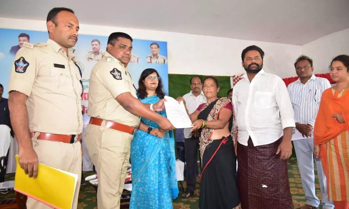 Krishna district SP P Joshuva and Joint Collector Dr Aparajitha Singh handing over cheques to a woman under Operation Parivarthan in Machilipatnam on Tuesday