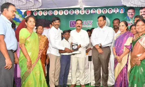 Agriculture minister K Govardhan Reddy, Kavali MLA R P K Reddy distributing tablets to students at ZP High School in Kavali on Wednesday