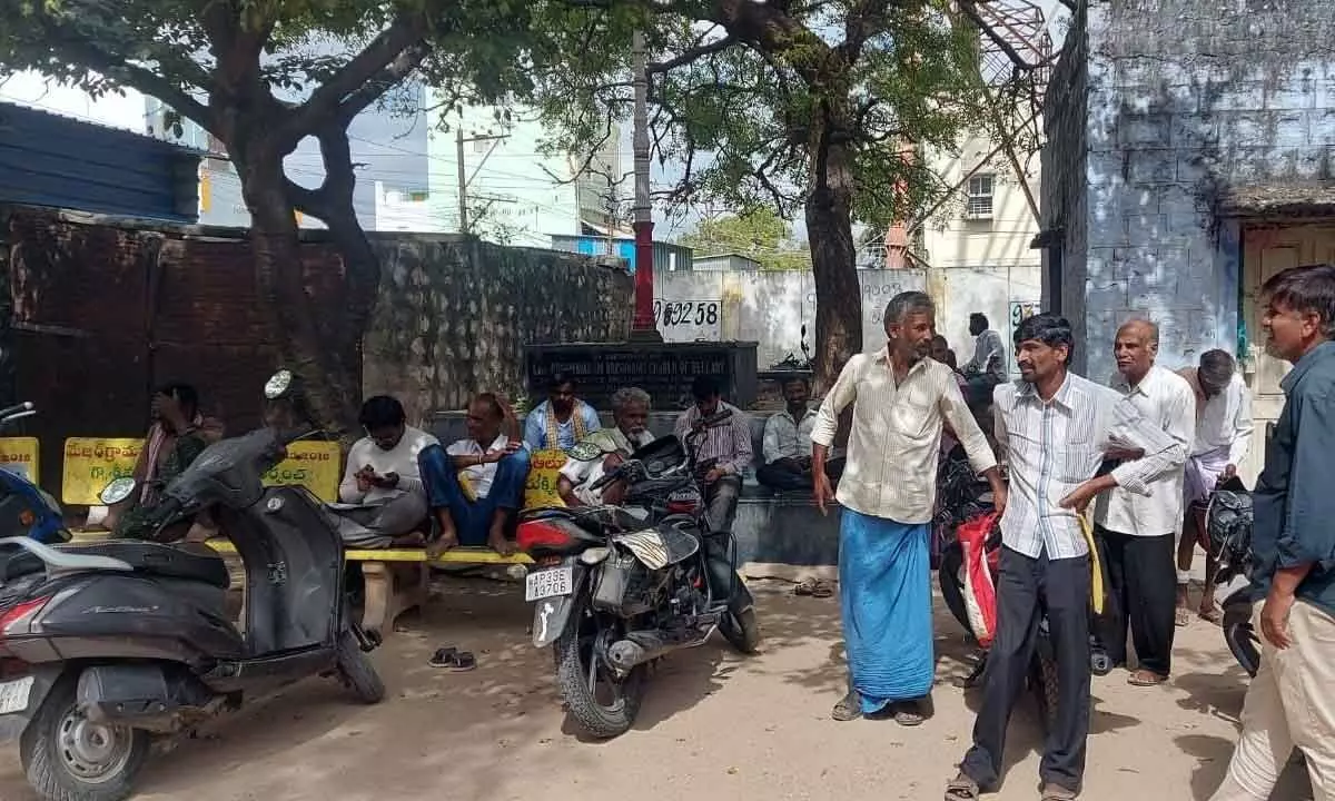 Farmers and other people waiting outside the Alur tahsildar’s office on Monday