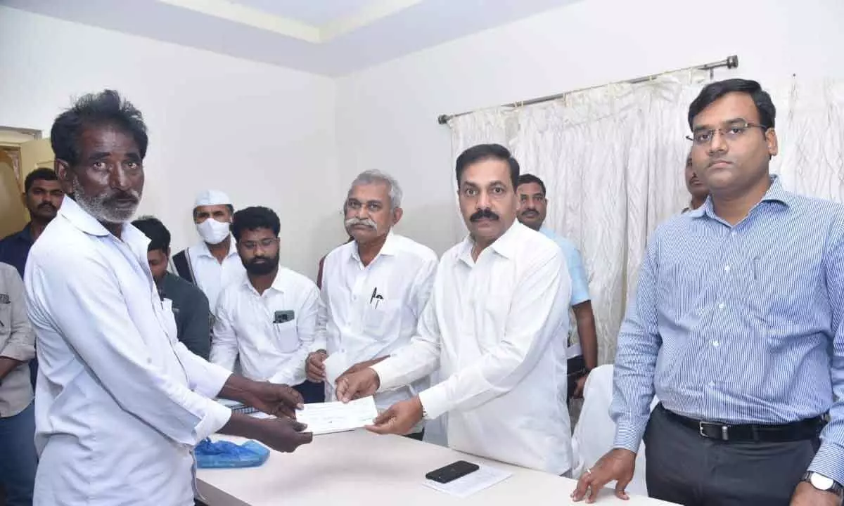 Agriculture Minister K Govardhan Reddy handing over ex gratia to family members of stampede victims at sub collectors office in Kandukuru on Friday