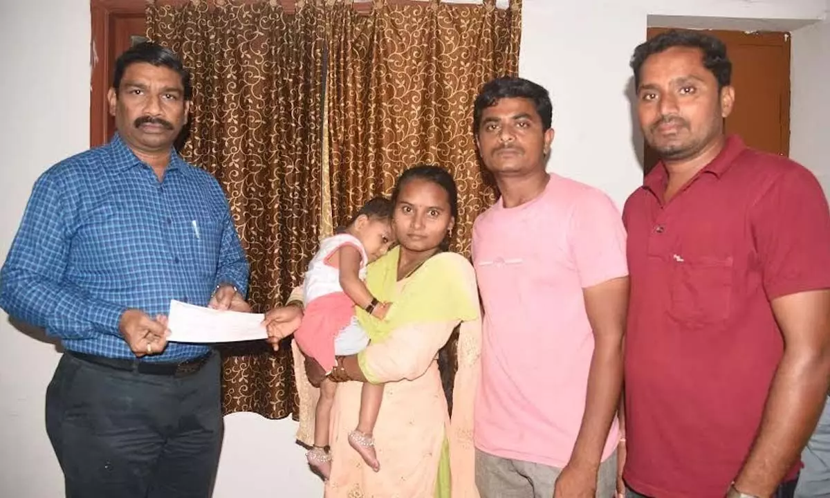District Collector Ravi Subhash handing over a cheque for Rs 1 lakh to patient in Anakapalli