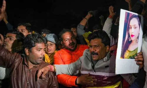 People raise slogans during their protest demanding justice for the 20-year-old woman who was killed after being hit and dragged by a car
