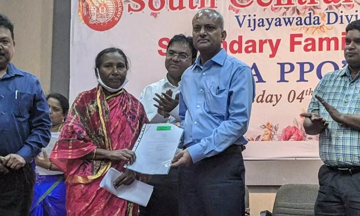 DRM Shivendra Mohan handing over PPO to a beneficiary at a programme at Railway Auditorium in Vijayawada on Wednesday
