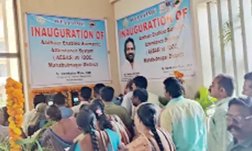 Employees of the Collectorate gather near the newly launched biometric attendance registration system at new District Collectorate in Mahabubnagar on Wednesday