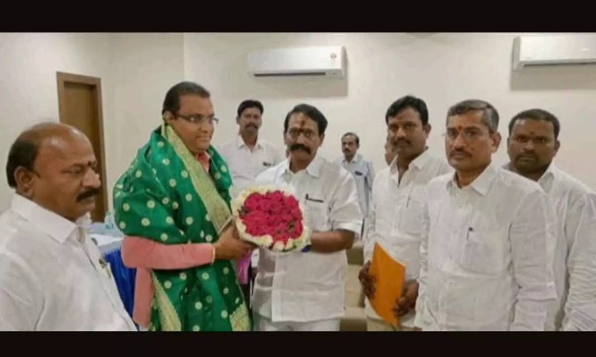 Mantralayam MLA Y Bala Nagi Reddy handing over a bouquet to the secretary of roads and buildings P S Pradyumna in Mantralayam on Thursday.