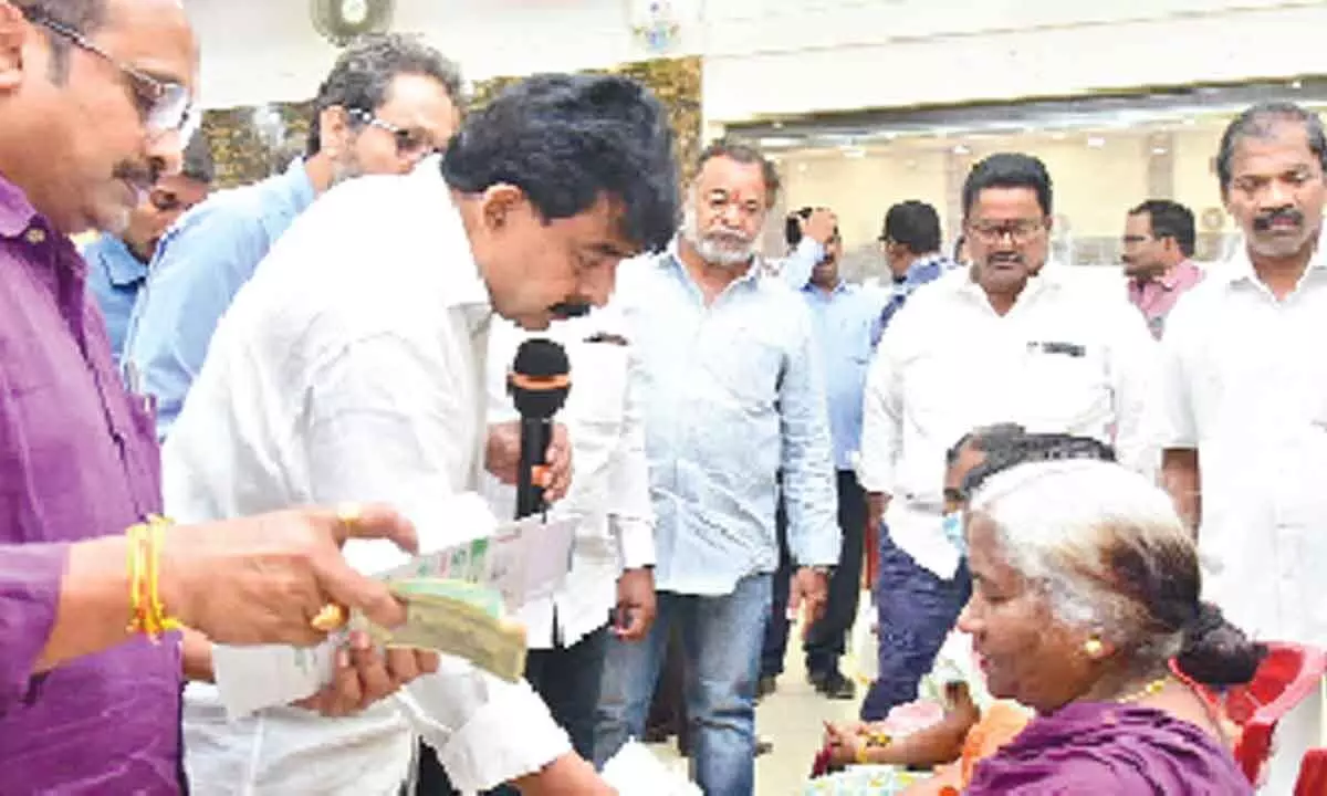 MLA Perni Venkatramaiah distributing pensions in Machilipatnam on Friday