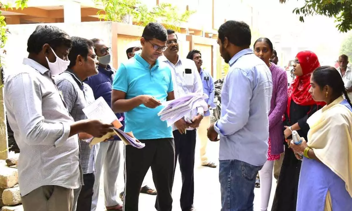 Civic Chief Swapnil Dinkar Pundkar checking the bills during inspection of the development works in Vijayawada on Friday