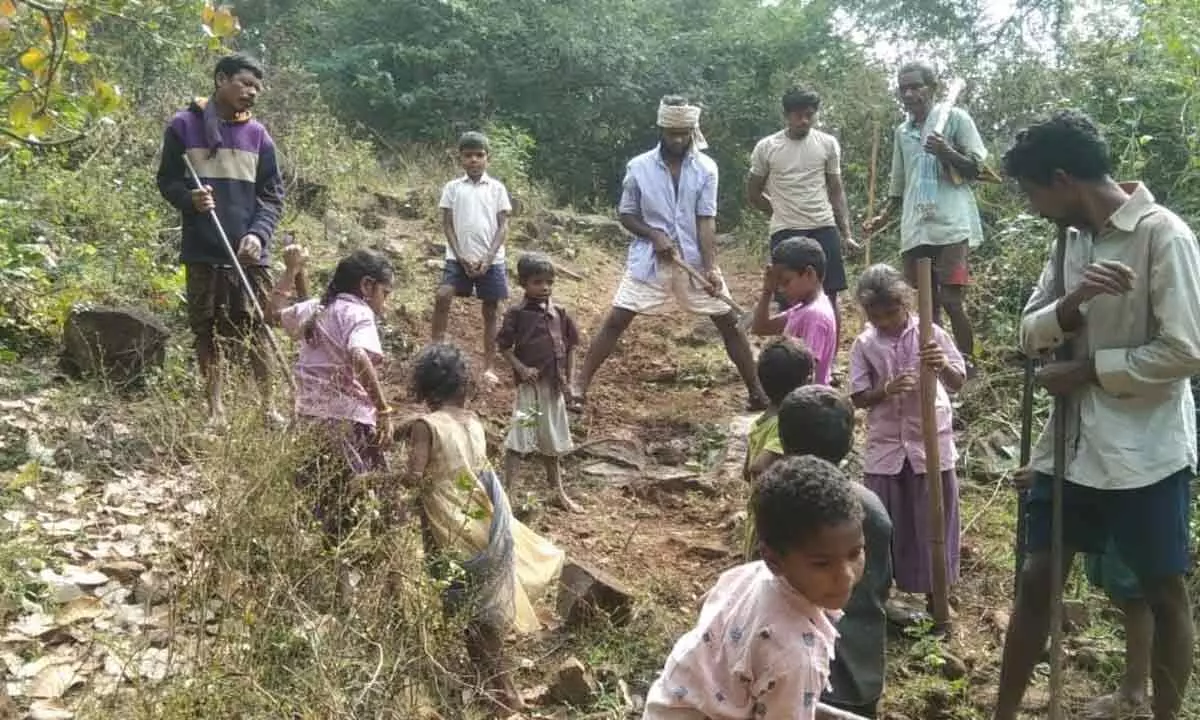 Tribal people and children engaged in construction of a road from Nereduband village to Jaggampeta school