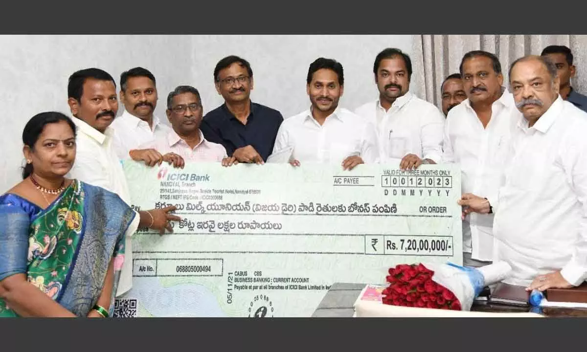 Chief Minister Y S Jagan Mohan Reddy hands over the cheque to Kurnool Milk Union (Vijaya Dairy) officials at his camp office in Tadepalli on Monday