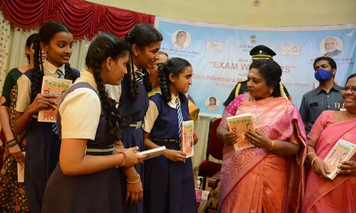 Governor Tamilisai Soundararajan speaks with a student during the launch of Exam Warriors authored by Prime Minister Narendra Modi, at Raj Bhavan on Thursday. Photo: Srinivas Setty