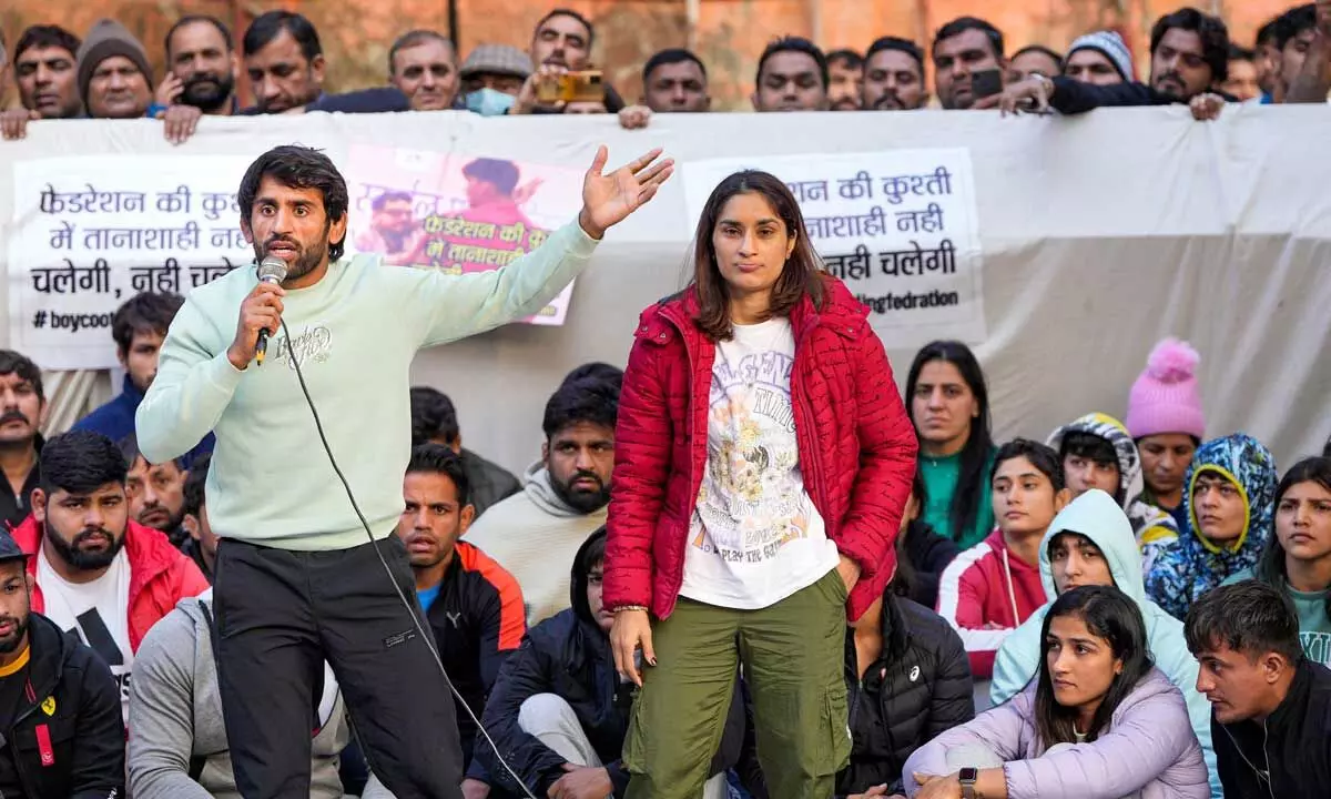 Wrestler Bajrang Punia speaks as fellow wrestler Vinesh Phogat looks on during their ongoing protest against the Wrestling Federation of India (WFI), at Jantar Mantar in New Delhi on Friday