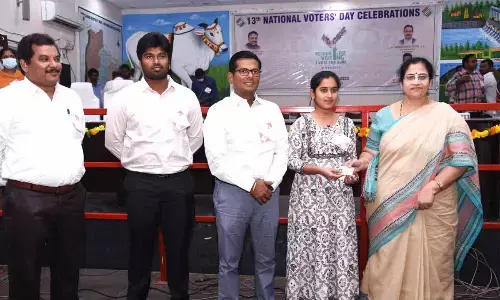 District judge A Bharathi, District Collector AS Dinesh Kumar and other officials presenting voter ID card to a new voter at the Collectorate in Ongole on Wednesday