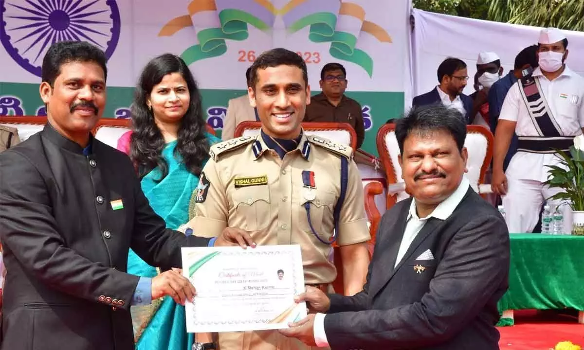 NTR District Collector S Dilli Rao and DCP Vishal Gunny handing over meritorious certificates to an employee in Vijayawada on Thursday