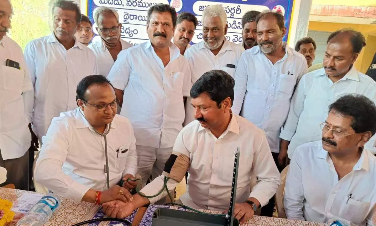 Doctors conducting medical tests on Minister Jogi Ramesh at a free medical camp held at Kankatava village on Sunday