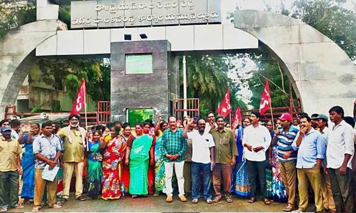 Municipal workers staging a protest at the Municipal office in Nellore on Monday