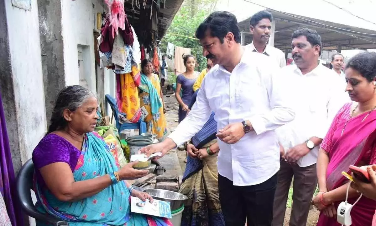 Housing Minister Jogi Ramesh handing over pension amount to a beneficiary in Pedana on Wednesday