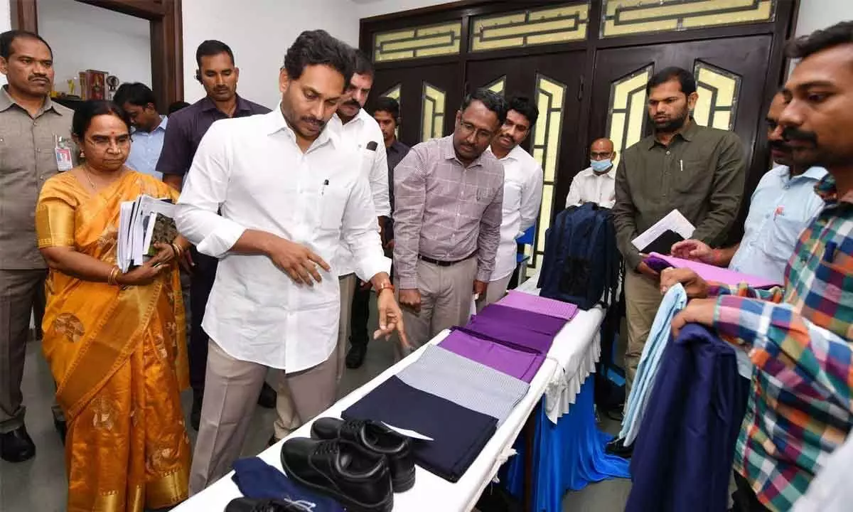 Chief Minister Y S Jagan Mohan Reddy examines the contents of Jagananna Vidya Kanuka kits to be distributed to students in next academic year, during a review on school education in Tadepalli on Thursday